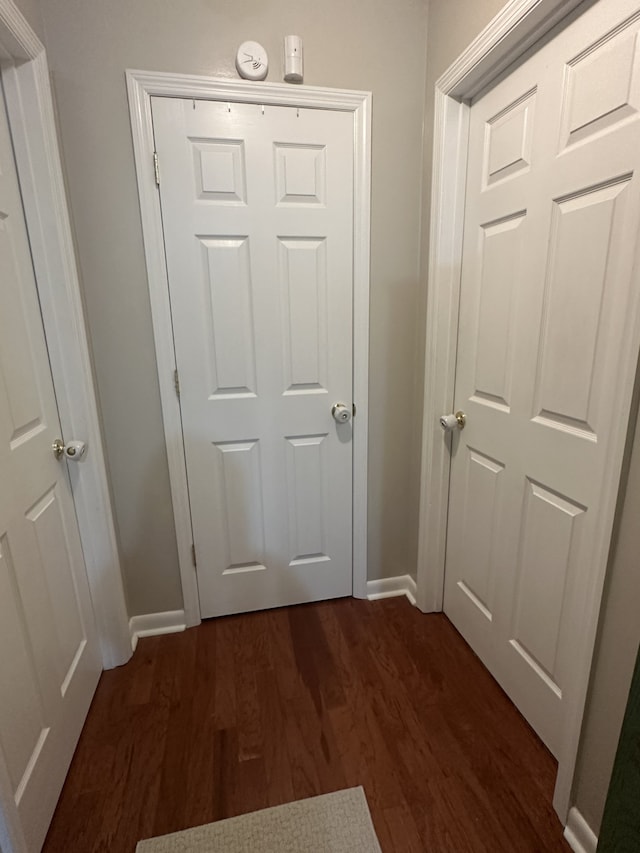 corridor with dark hardwood / wood-style flooring