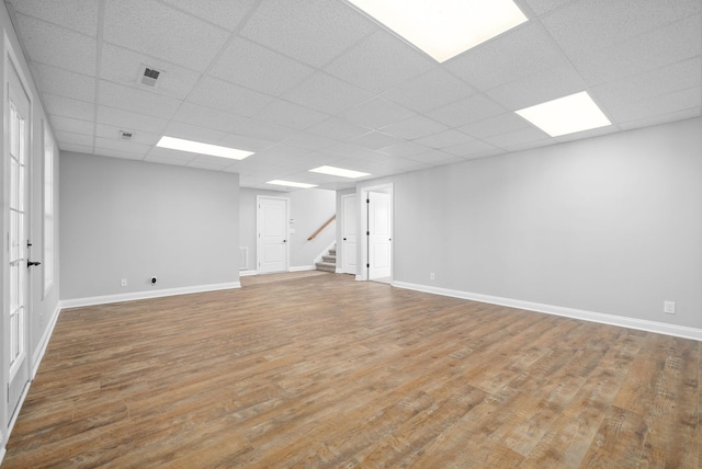 basement featuring hardwood / wood-style floors and a paneled ceiling