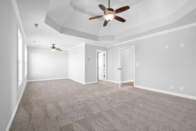 empty room featuring ceiling fan, ornamental molding, carpet, and a tray ceiling