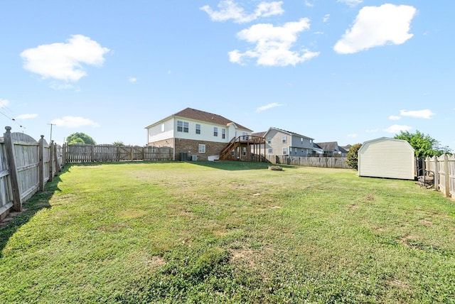 view of yard with a storage shed, cooling unit, and a wooden deck