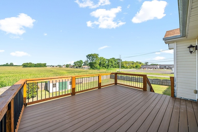 wooden terrace with a yard and a rural view