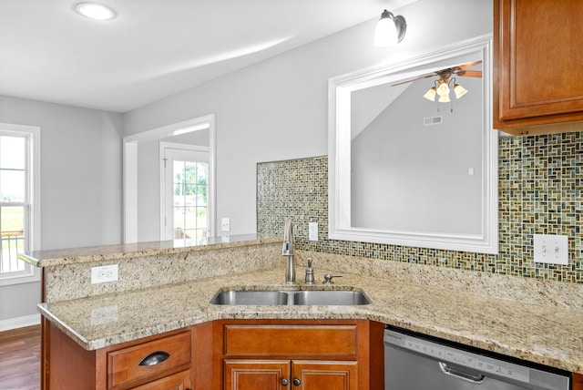 kitchen featuring tasteful backsplash, dishwasher, sink, and plenty of natural light