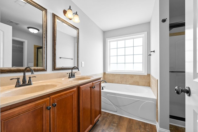 bathroom featuring a tub to relax in, vanity, and hardwood / wood-style flooring