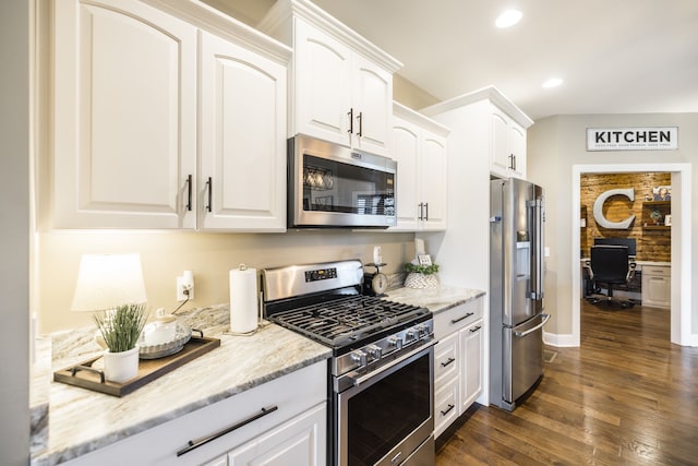 kitchen featuring appliances with stainless steel finishes, white cabinetry, light stone counters, and dark wood-type flooring