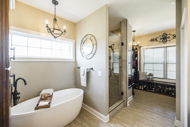 bathroom with independent shower and bath, tile patterned floors, and an inviting chandelier