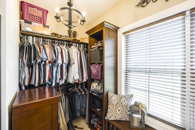 walk in closet featuring a notable chandelier