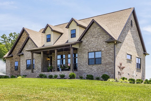 view of front of property with a porch, brick siding, roof with shingles, crawl space, and a front lawn