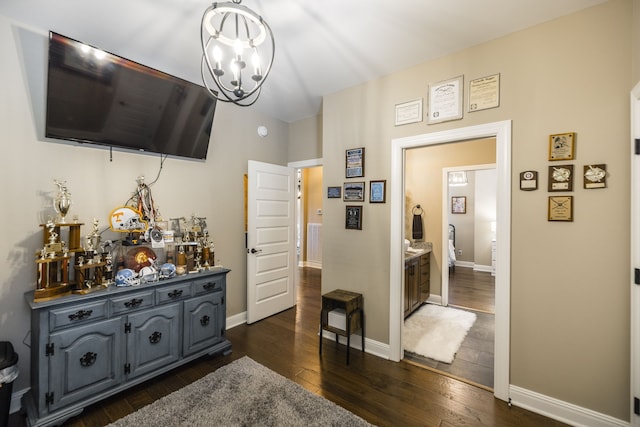 hallway with dark hardwood / wood-style floors and an inviting chandelier