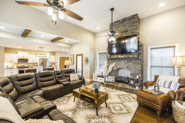 living room featuring a stone fireplace, dark wood-type flooring, and ceiling fan