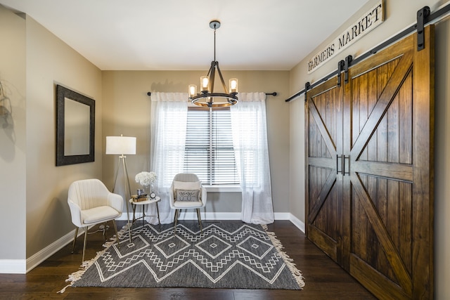 living area with a barn door, dark hardwood / wood-style floors, and a chandelier