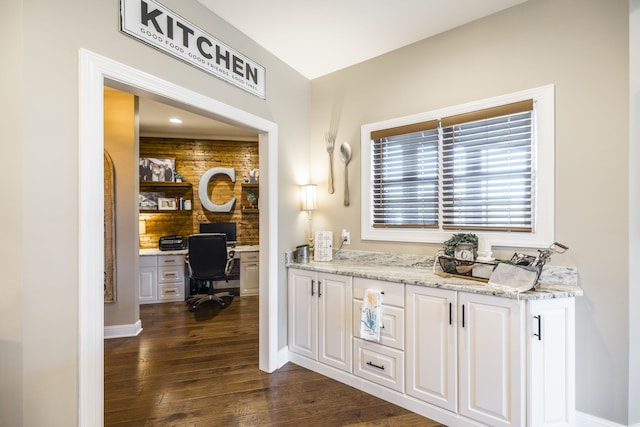 interior space with light stone countertops, dark hardwood / wood-style flooring, and white cabinets