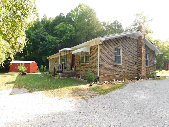 view of front of house with a front lawn and a shed