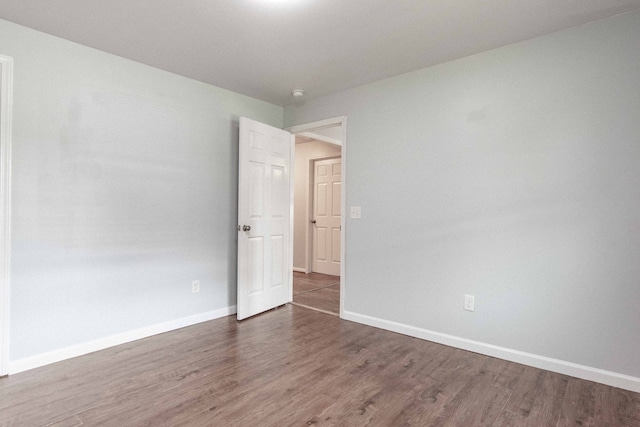 unfurnished room featuring dark wood-type flooring