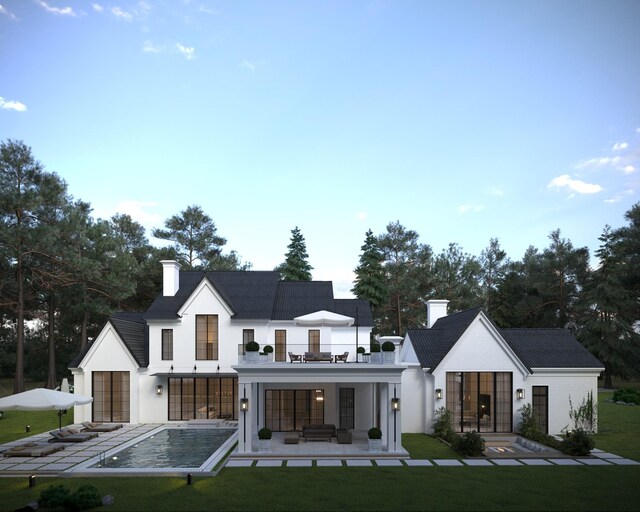 rear view of house with a patio area, a balcony, and a yard