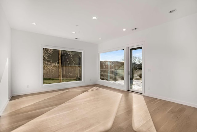 empty room featuring visible vents, recessed lighting, baseboards, and light wood-type flooring