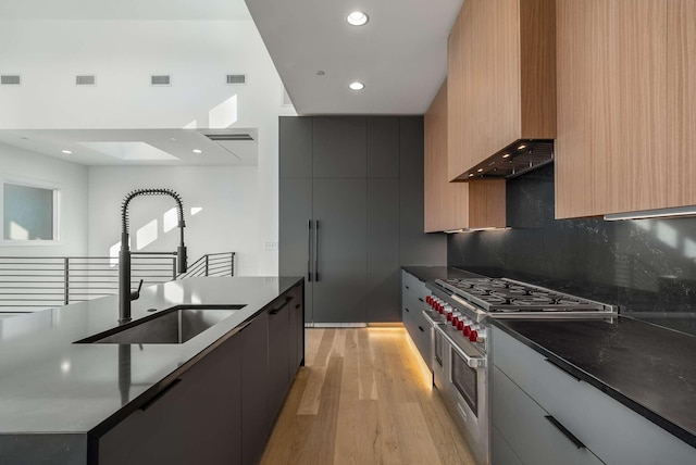 kitchen with a sink, modern cabinets, visible vents, and range with two ovens