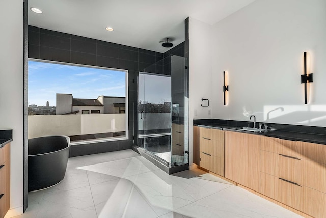 full bathroom with marble finish floor, recessed lighting, a shower stall, a soaking tub, and vanity