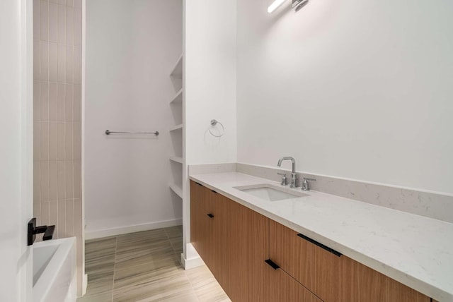 bathroom featuring baseboards, a bathtub, tile patterned floors, vanity, and a shower