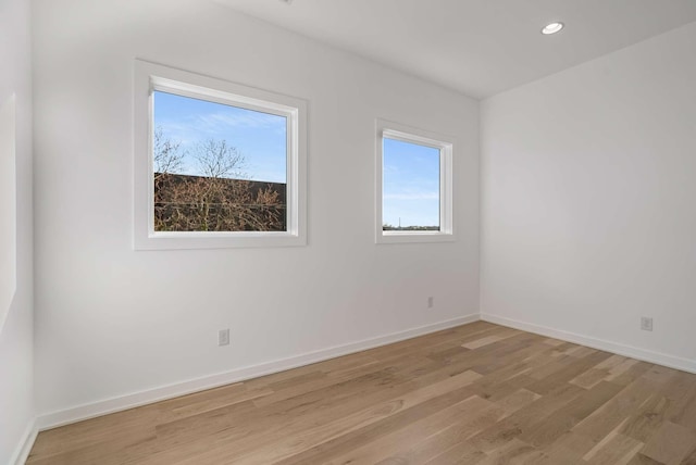 empty room with recessed lighting, baseboards, and light wood finished floors