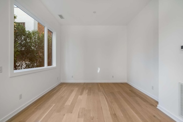 spare room with visible vents, light wood-style flooring, and baseboards