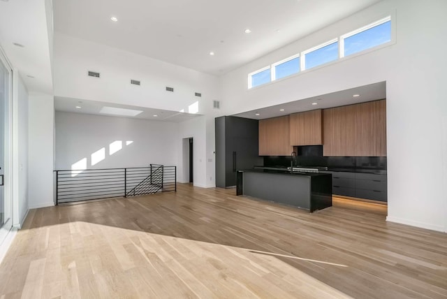 kitchen with light wood-style flooring, dark countertops, modern cabinets, and open floor plan