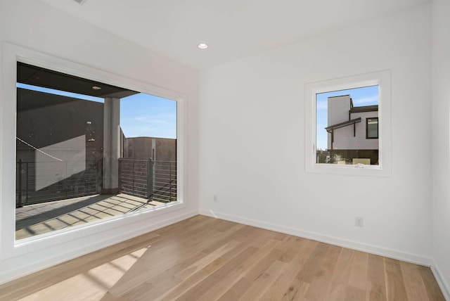 empty room with recessed lighting, baseboards, and wood finished floors