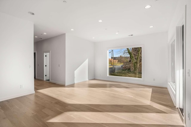 unfurnished room with recessed lighting, light wood-type flooring, and baseboards