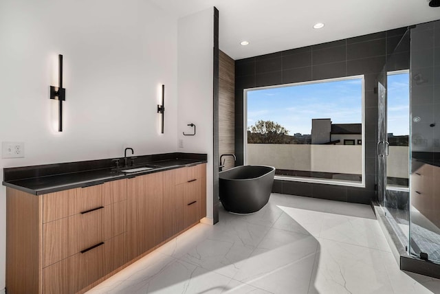 full bath featuring vanity, recessed lighting, a stall shower, a freestanding bath, and marble finish floor