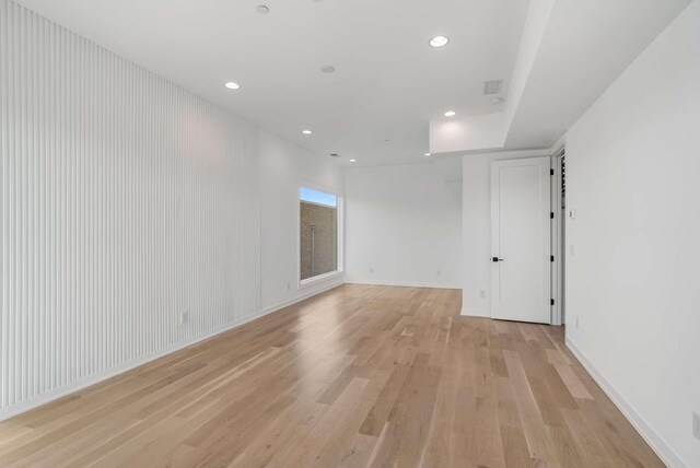 spare room featuring recessed lighting, light wood-style floors, and baseboards