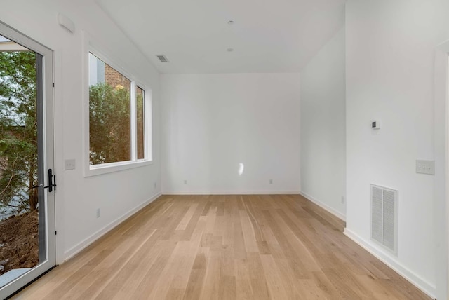 unfurnished room featuring visible vents, light wood-type flooring, and baseboards