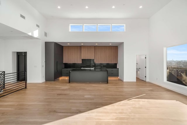 kitchen featuring dark countertops, open floor plan, light wood-style flooring, and modern cabinets