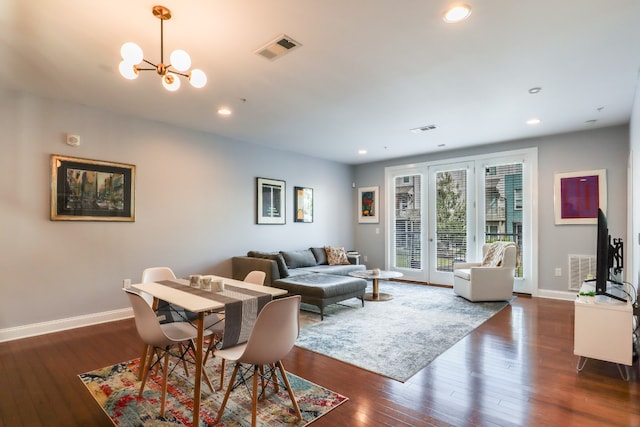 living room featuring dark hardwood / wood-style flooring, a chandelier, and french doors