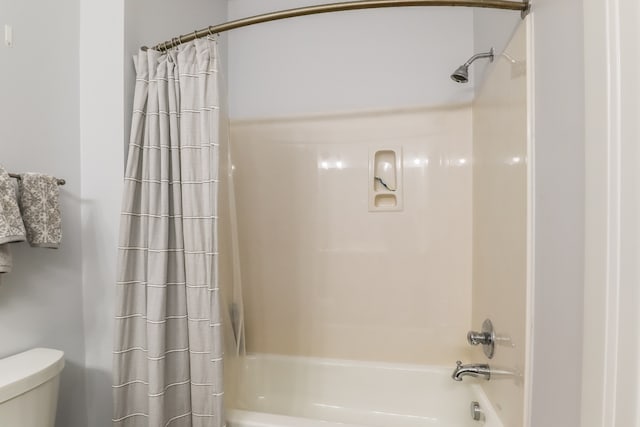 bathroom with toilet and shower / bath combination with curtain