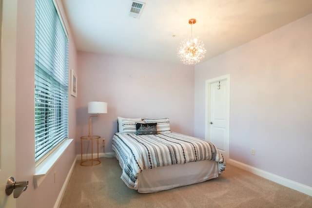 carpeted bedroom featuring a chandelier