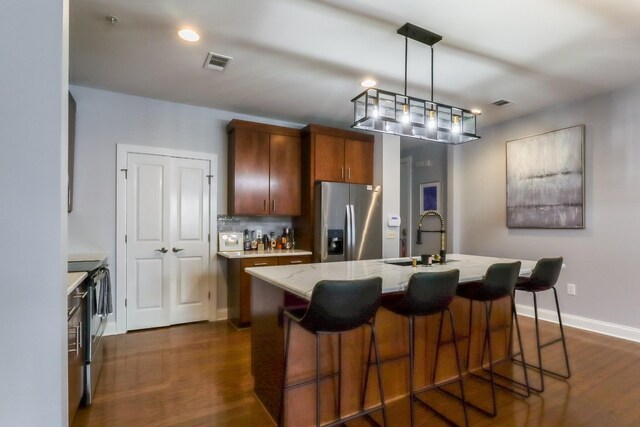 kitchen featuring appliances with stainless steel finishes, sink, pendant lighting, decorative backsplash, and dark hardwood / wood-style floors