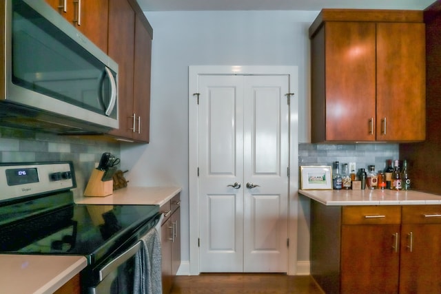 kitchen featuring stainless steel appliances, dark hardwood / wood-style flooring, and tasteful backsplash