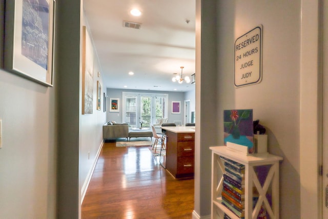 hallway featuring dark hardwood / wood-style floors and a chandelier