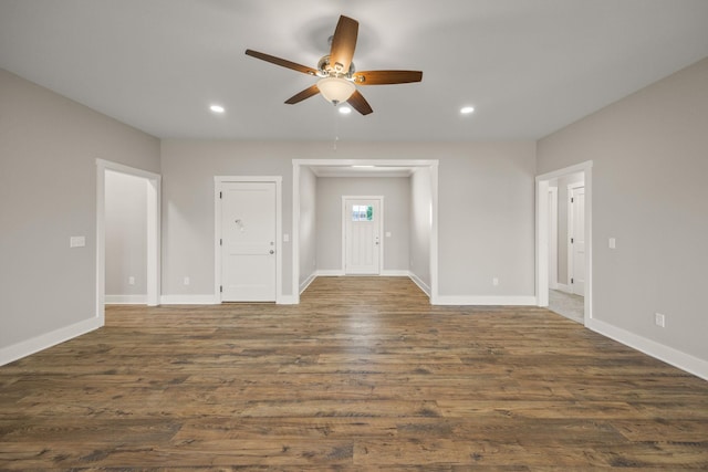 unfurnished living room featuring ceiling fan and dark hardwood / wood-style floors