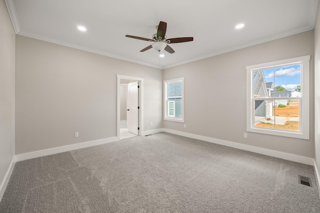 carpeted empty room with ceiling fan and crown molding