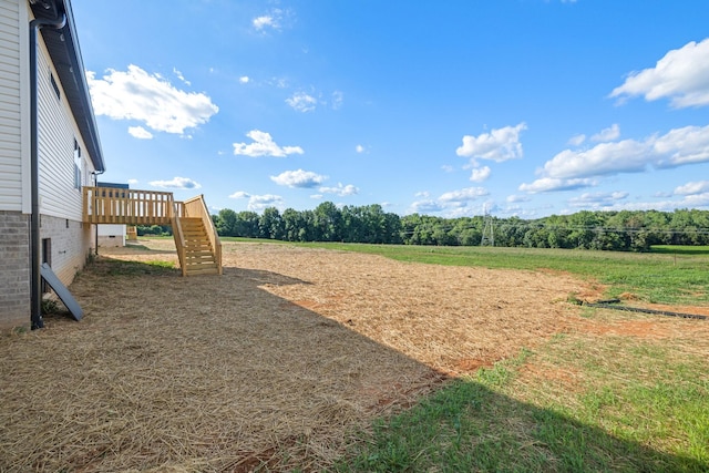 view of yard with a rural view and a deck