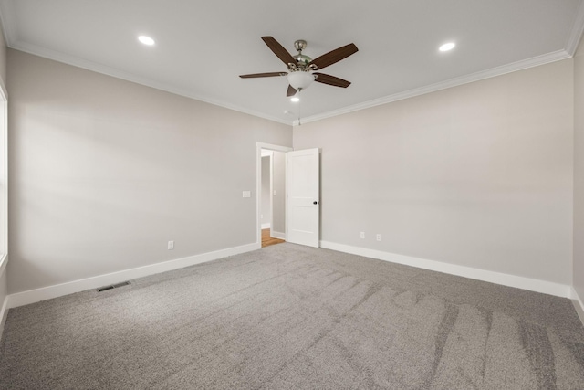 carpeted spare room featuring ceiling fan and crown molding