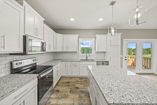 kitchen featuring decorative light fixtures, white cabinetry, stainless steel appliances, decorative backsplash, and sink