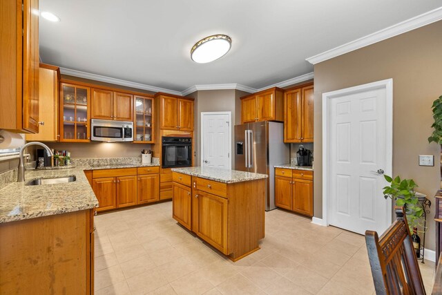 kitchen with sink, ornamental molding, a center island, stainless steel appliances, and light stone countertops