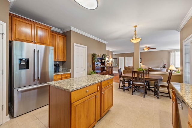 kitchen featuring ornamental molding, stainless steel fridge, light stone countertops, and hanging light fixtures