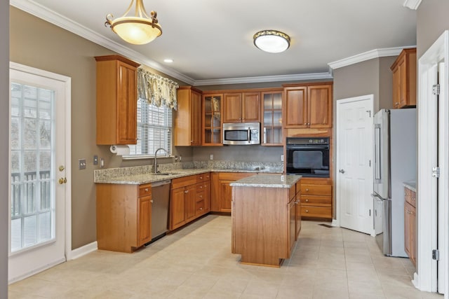 kitchen featuring light stone counters, a center island, ornamental molding, appliances with stainless steel finishes, and pendant lighting