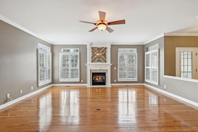 unfurnished living room with crown molding, a healthy amount of sunlight, and light wood-type flooring