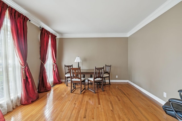 dining space featuring crown molding, light hardwood / wood-style flooring, and a wealth of natural light