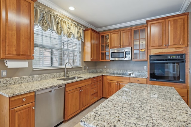 kitchen featuring light stone counters, sink, ornamental molding, and appliances with stainless steel finishes