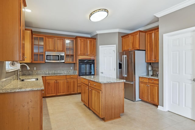 kitchen with sink, crown molding, appliances with stainless steel finishes, a center island, and light stone countertops