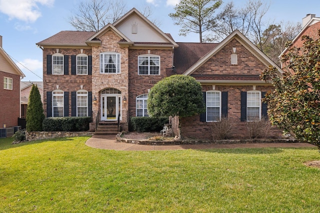 view of front of property with central AC and a front lawn